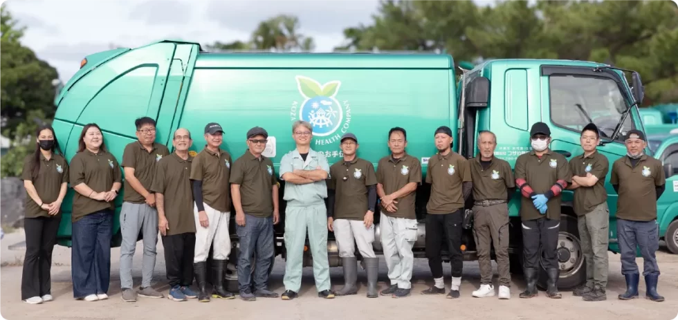 パッカー車をバックにした社員集合写真